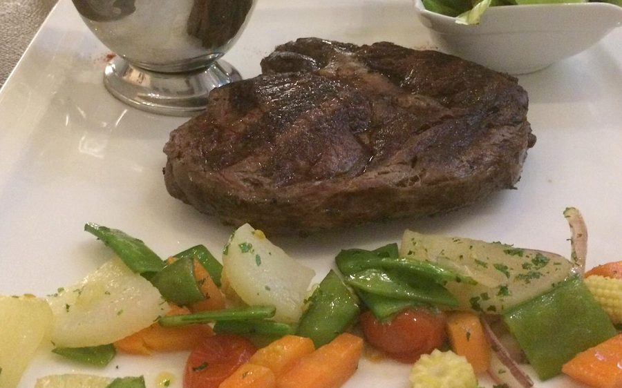 Charbroiled steak dinner with vegetables and salad
