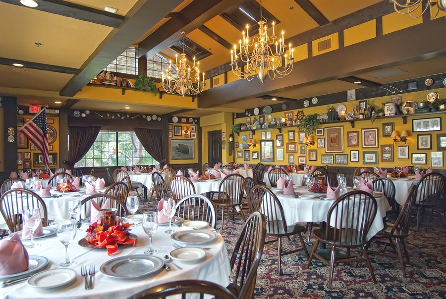 Gulliver's banquet room set with white linens, pewter plates and brass chandeliers